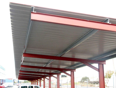 Estructura metálica roja de un estacionamiento techado